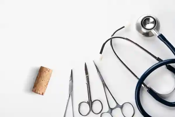 Medizinialbesteck ist ordentlich auf weissem Hintergrund aufgereit, ganz Links ist ein Flaschenkorken platziert.
